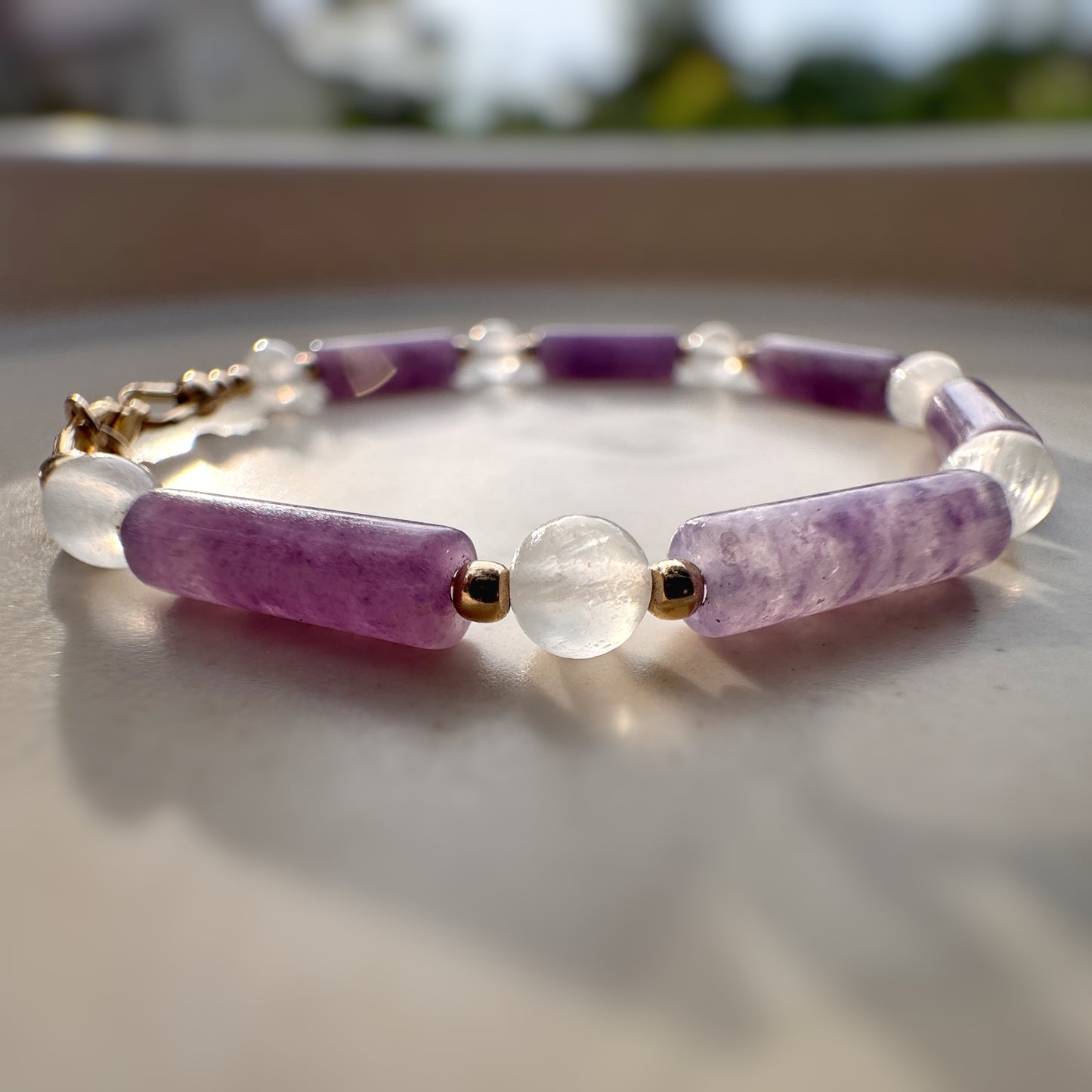 Bracelet with purple and clear beads on a neutral background